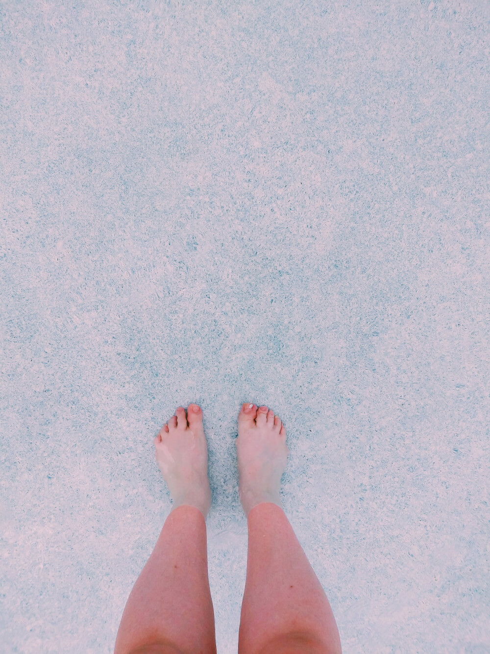 From where I stand in 4 inches' deep pool water; unpainted toenails
