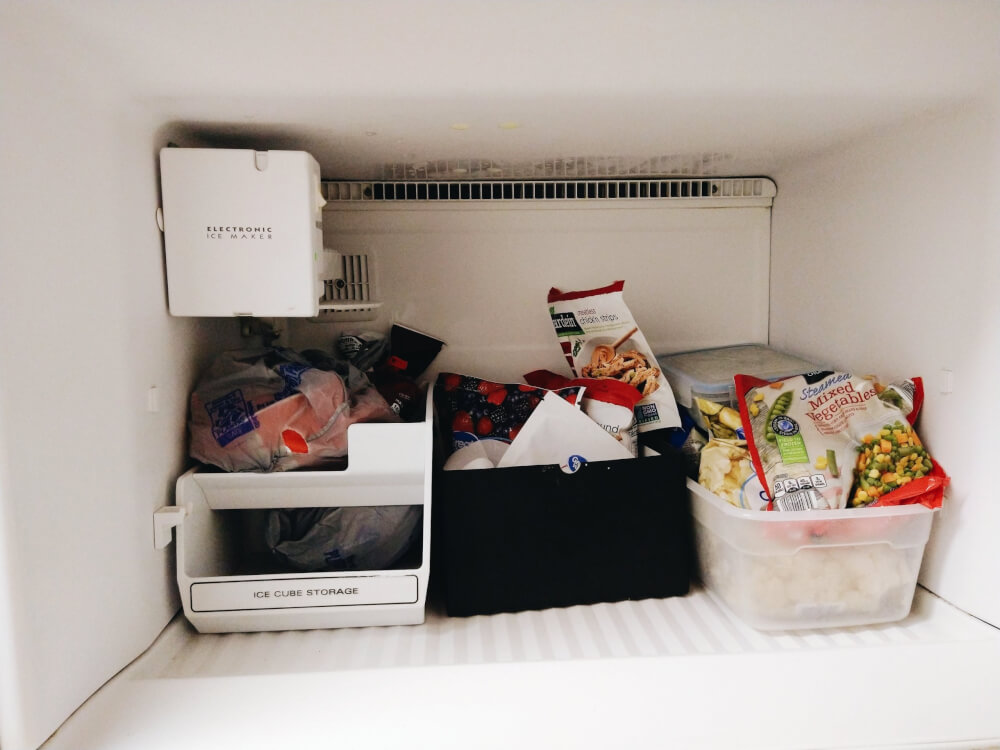 Freezer full of frozen fruit, veggies and vegan meats; it's an organized mess