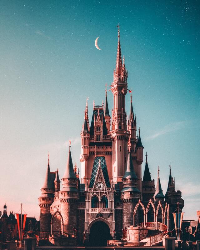 Walt Disney castle before cotton candy sky and crescent moon